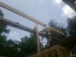 Carpenter setting a ridge beam over a new addition frame — Ice Dam Removal by Roofing Brothers in Ceres